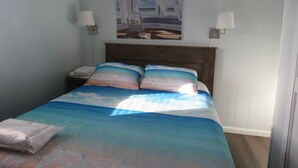 Ein Schlafzimmer mit einem Bett, Nachttischen und einem Bild an der Wand.