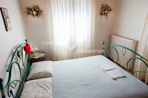 2 dormitorios y tabla de planchar con plancha