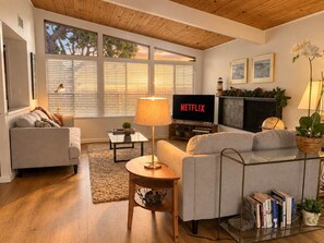 A living room with a sofa, a coffee table, a TV, and a fireplace.