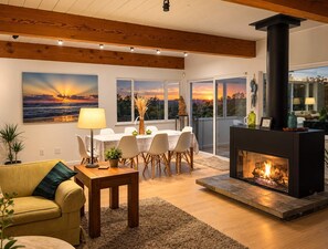 Ein modernes Wohnzimmer mit Kamin, Essbereich und großen Fenstern mit Blick.