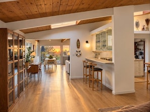 🍽️ Open-concept kitchen and dining with vaulted wood-beam ceilings—a warm, airy space built for gathering. - Ocean & Bay Sunset Views from Family Oasis, Hottub (San Diego)