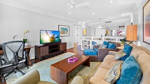 A modern living room with a TV, sofa, and office chair.