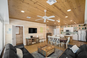 Un intérieur de chalet chaleureux comprenant un coin repas, une cuisine et un salon.