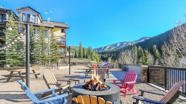 Une terrasse avec des sièges extérieurs, un foyer et une vue sur les montagnes.