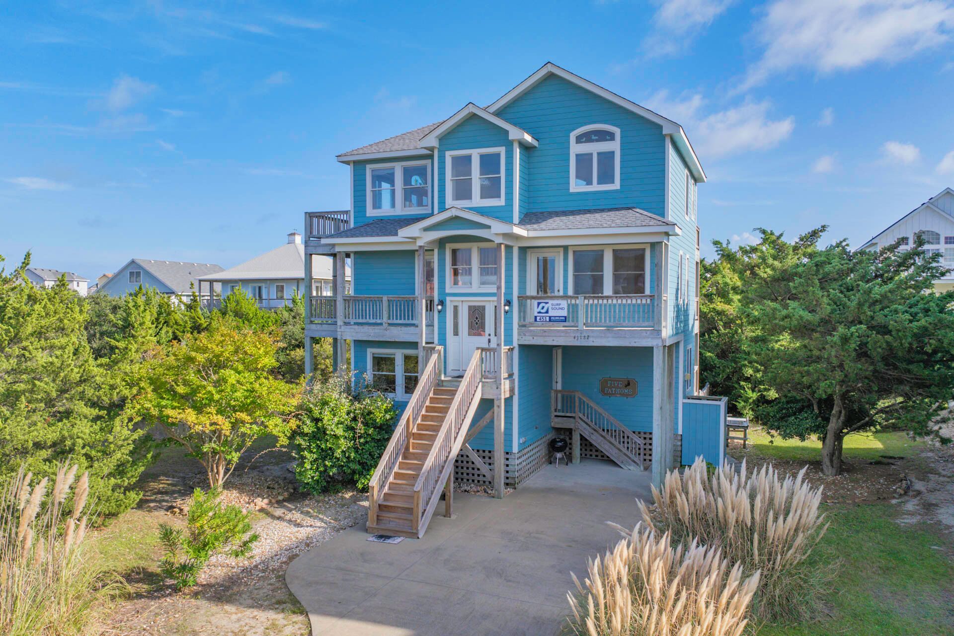 A two-story house with a balcony, a staircase, and a front porch.
