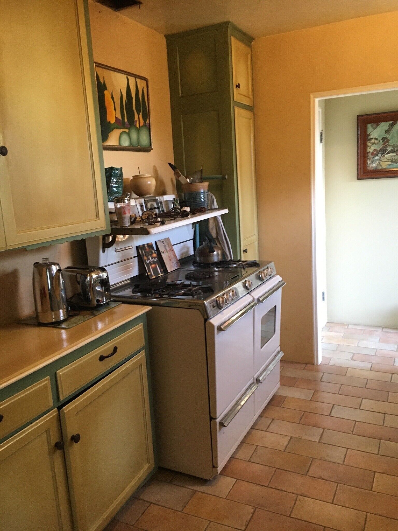 A kitchen with a stove, oven, and various kitchen utensils.