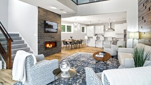 A modern living room with a fireplace, a dining area, and a kitchen. - MINNeSTAY* Lakefront Luxury (Mound)
