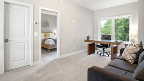 Un dormitorio moderno con cama, escritorio y ventana.