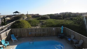 A backyard with a swimming pool, wooden deck, and lounge chairs. - LastMinuteSpecial/OceanFront/Pool/HotTub/XBOXoneS/ping pong table (Nags Head)