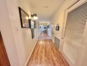 Stylish hallway with framed artwork and a door leading to a room.
