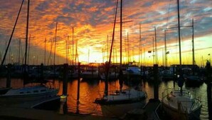Un port de plaisance où de nombreux voiliers sont amarrés au quai au coucher du soleil.