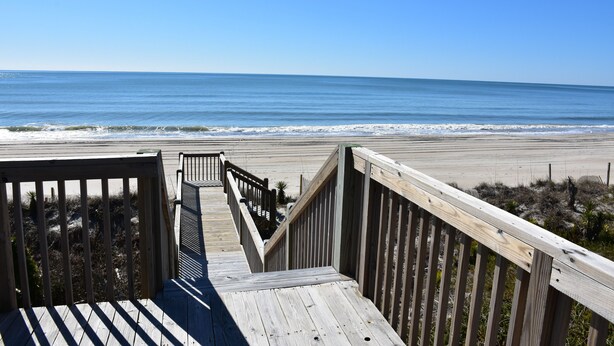 A wooden boardwalk leading to a beach with a clear view of the ocean. - Oceanfront Cottage with Private Beach Access (Emerald Isle)