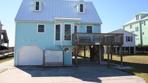 A two-story house with a blue exterior and a wooden deck. - Oceanfront Cottage with Private Beach Access (Emerald Isle)