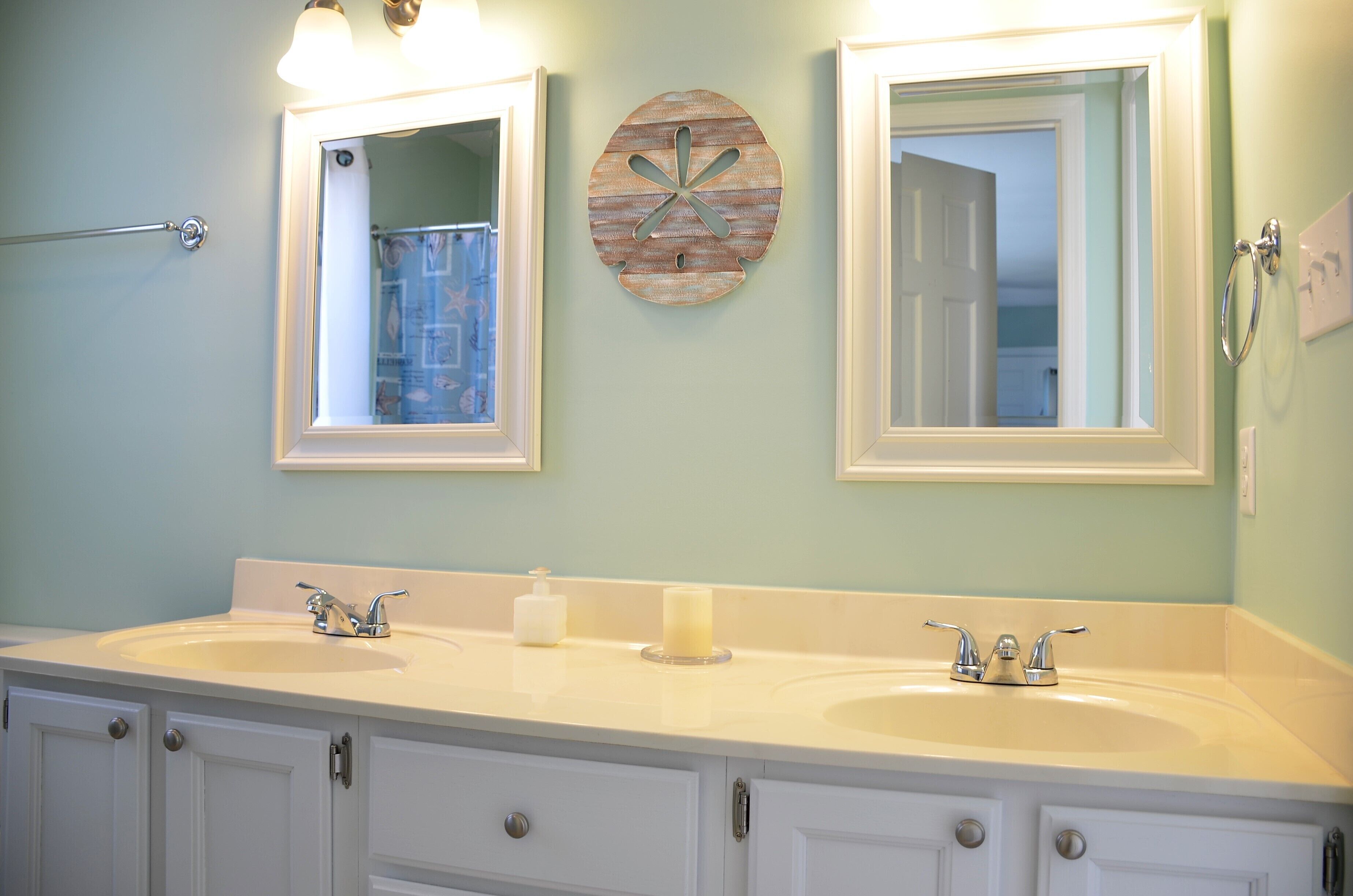 Une salle de bain avec deux lavabos, un porte-serviettes et un élément décoratif mural.