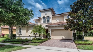 A two-story house with a beige facade, a tiled roof, and a garage.