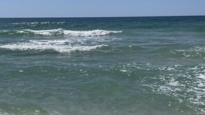A beach with clear water and waves. -  Gorgeous Sunsets!!  We now have some openings for first part of Aug.    (Orange Beach)