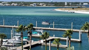 A marina with boats docked, a pier with benches, and a beach in the background. -  Gorgeous Sunsets!!  We now have some openings for first part of Aug.    (Orange Beach)