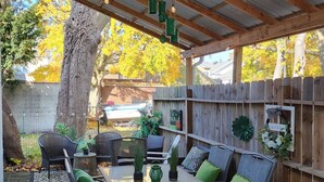 Un patio al aire libre con zona de estar techada, una mesa y sillas.