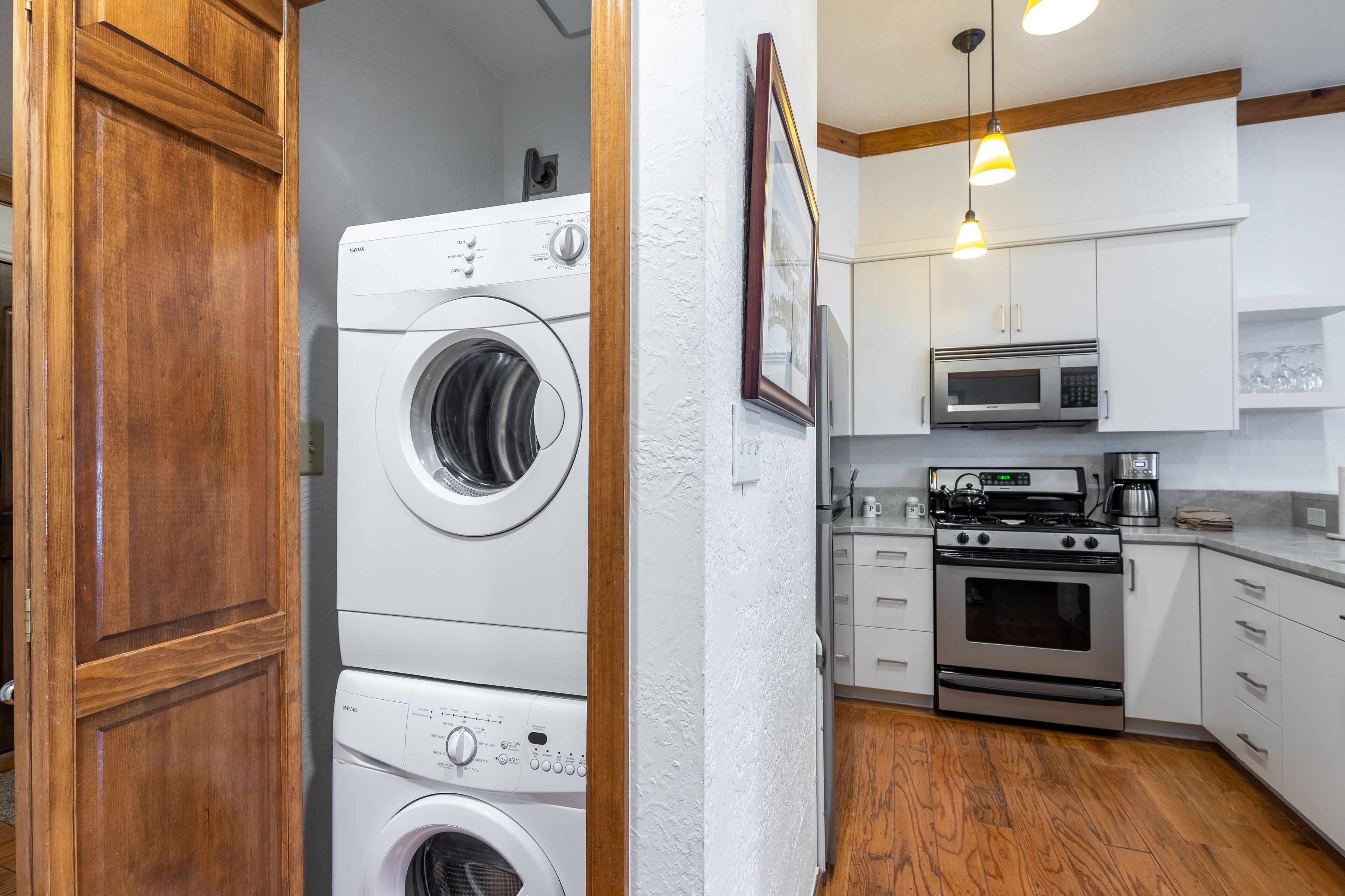 Une cuisine compacte équipée d’un lave-linge, d’un four à micro-ondes et d’un four traditionnel.