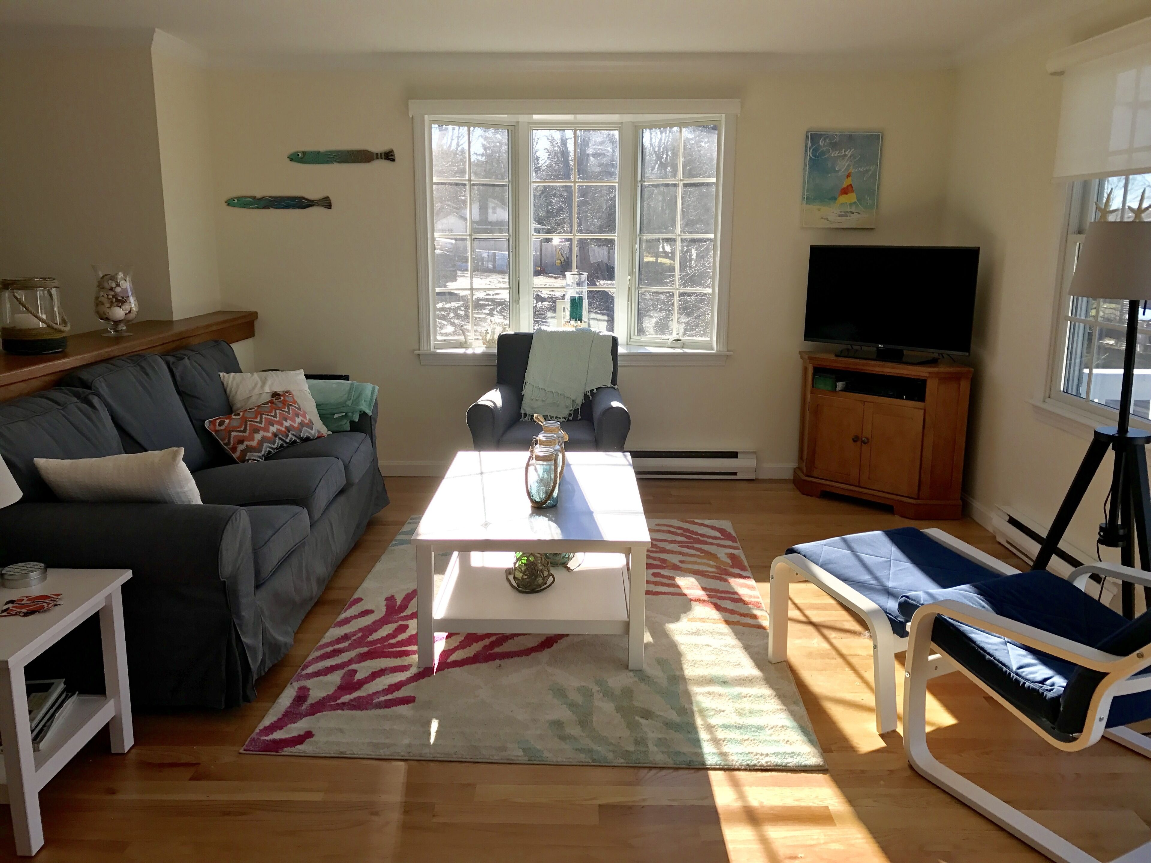 A living room with a sofa, a coffee table, a TV, and a chair.