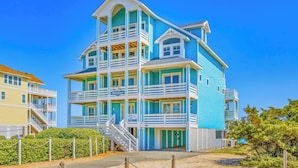 A multi-story building with balconies and a sign that reads 'Moonshine.' - Premier Oceanfront Dog Friendly with Pool, Hot Tub, Elevator, Theater, Tiki Bar (Salvo)
