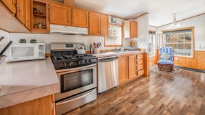 A kitchen with wooden cabinets, stainless steel appliances, and a window with a view. - Check our Reviews! Spectacular Views! King bed! Upgraded Baths n Kitchen! (Hunter)