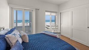Una camera da letto con un letto, una sedia, un armadio e vista sulla spiaggia.