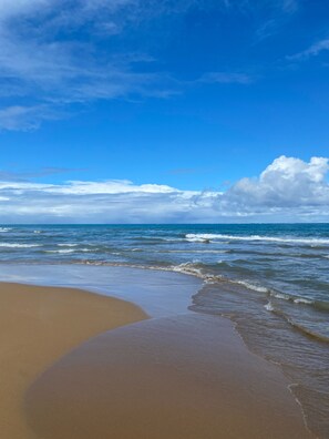 A beach with a curved shoreline and waves approaching the shore. - Beachfront Condo by the Wyndham RioMar 35 min from Airport 15 min El Yunque (Rio Grande)