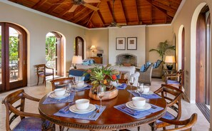 A dining area with a round table set for four, surrounded by wooden chairs. - Mango Bay: Amazing North Shore Views! (St. John)