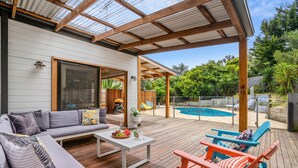 A covered outdoor patio with a pool, wooden deck, and seating area. - SALTWATER POOLSIDE -8m Heated* Pool, an entertainers delight -BONUS*NIGHTS 2026 (rye)