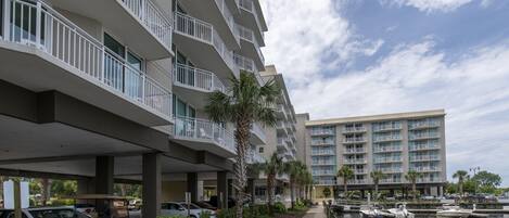 A waterfront hotel with multiple balconies, a marina, and a boardwalk.
