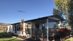 A single-story house with a porch, a chimney, and a satellite dish. - The Moon House. Come mingle with the stars. (Hotchkiss)