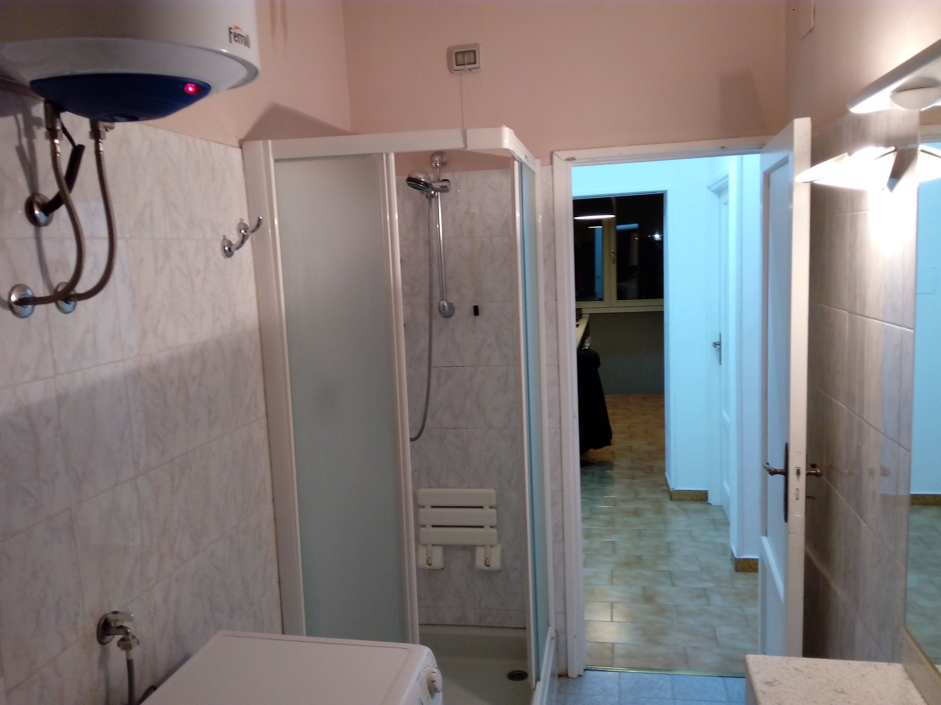 Une salle de bain avec une douche, des toilettes et un petit marchepied.