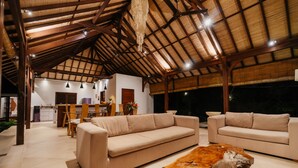A spacious living area with two sofas, a coffee table, and a kitchen in the background.
