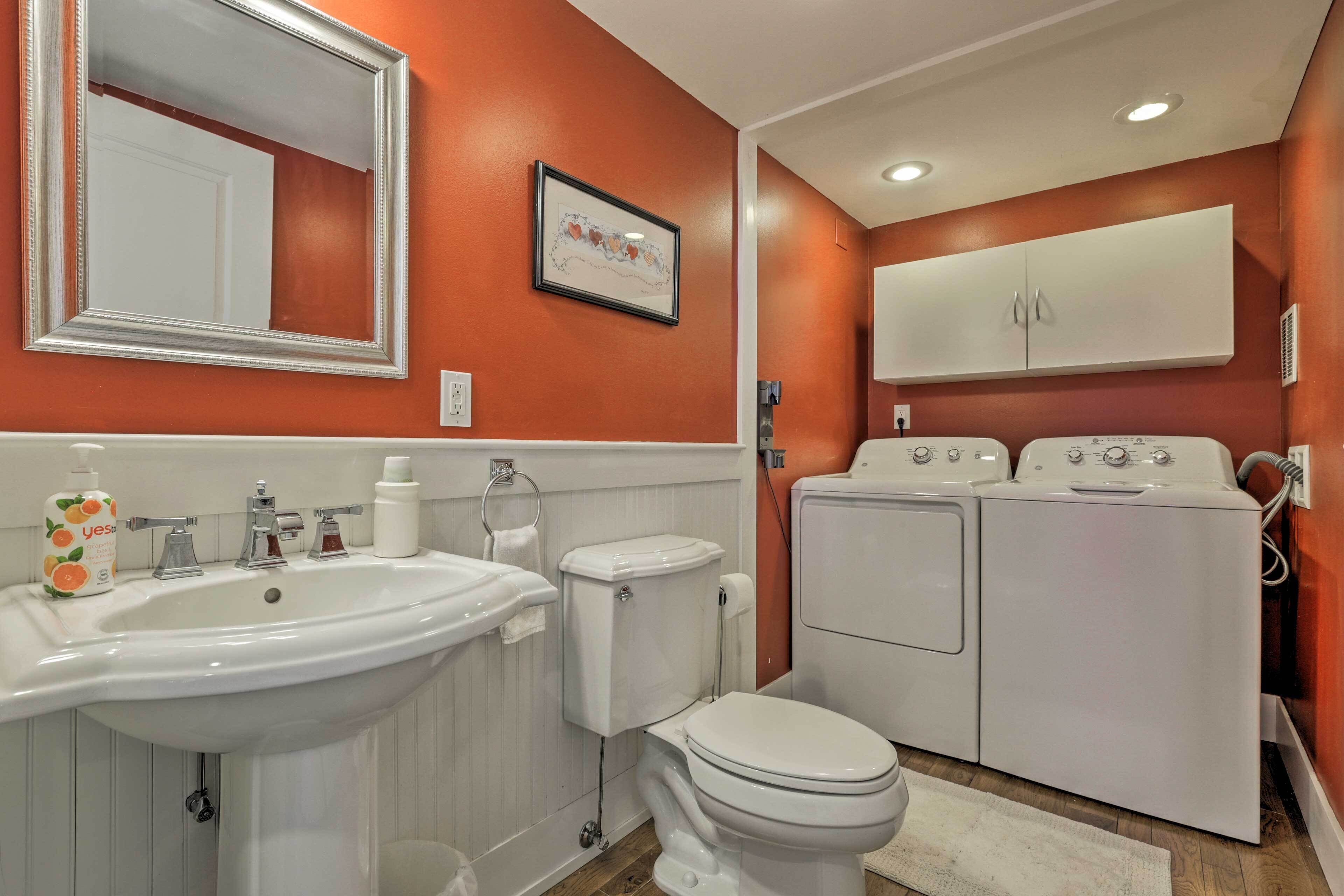 A bathroom with a sink, toilet, and stacked washer-dryer unit.