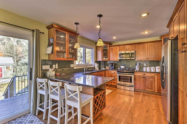 Enjoy cooking in this well-equipped kitchen with a large island, stainless steel appliances, and a view of the outdoors.