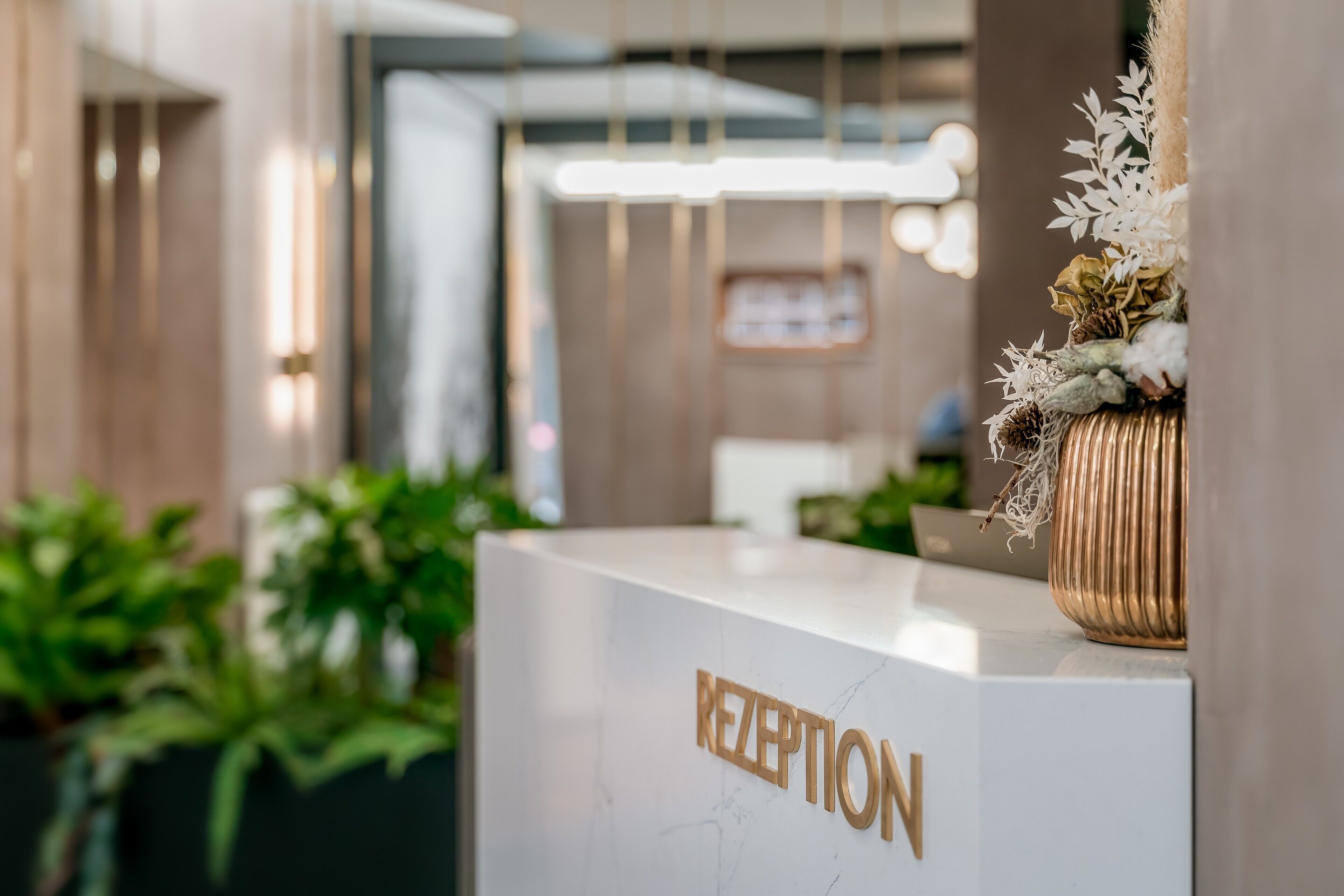 A reception desk with a marble top and the word "RECEPTION" in gold letters.
