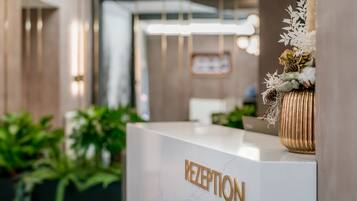 A reception desk with a marble top and the word "RECEPTION" in gold letters.