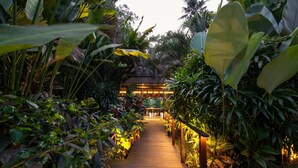 A wooden pathway leading to a building surrounded by lush tropical plants. - Ubud Villa - 4BR Jungle View (Ubud)