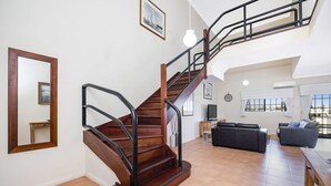 A wooden staircase with black railings, a mirror, and a framed picture on the wall. - Great value 2 bedroom apartment in the heart of South Fremantle (Fremantle)
