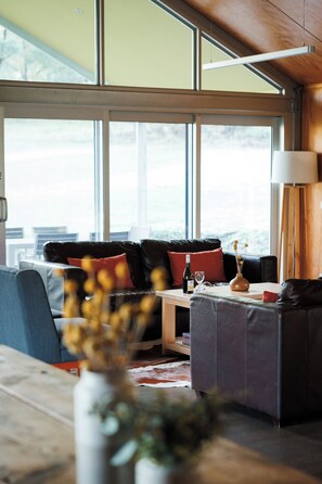 A modern living room with a sofa, a coffee table, and a lamp.