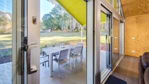 A modern interior with a sliding glass door leading to an outdoor patio area. - Nine Steps - private estate on 29 acres with stunning views of Mount Buffalo (Porepunkah)
