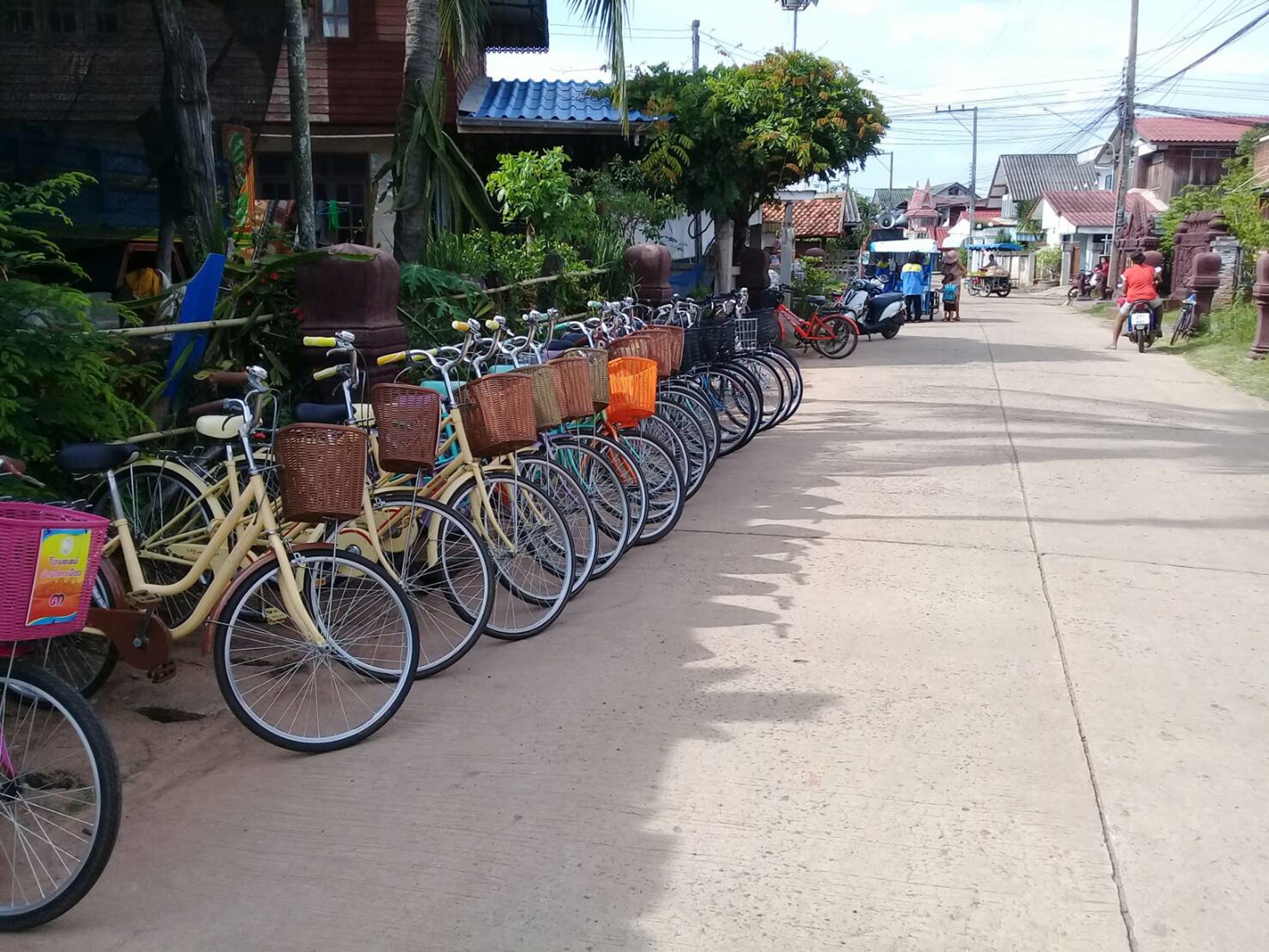 A row of bicycles parked along a sidewalk in a residential area.