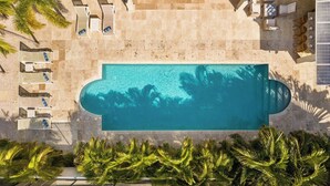 An aerial view of a swimming pool with lounge chairs and palm trees. - Upscale 5BR Villa: Game Room, Private Pool, Patio (Noord)