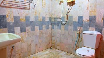 Een badkamer met toilet, wastafel en douche.