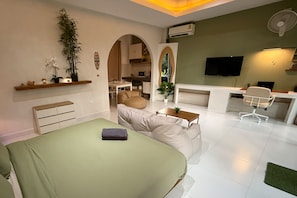 A modern bedroom with a bed, a desk, a chair, and a TV. - Beach Jungle Koh Chang (Ko Chang)