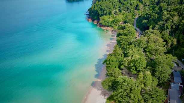 A coastal area with a beach, a road winding through a forest, and several small islands in the distance. - Beach Jungle Koh Chang (Ko Chang)