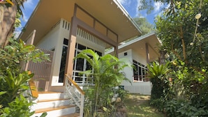 A modern house with a covered porch, a staircase, and lush greenery surrounding it. - Beach Jungle Koh Chang (Ko Chang)