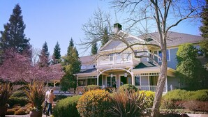Une grande maison à deux étages, dotée d’un porche imposant et d’un toit végétalisé.
