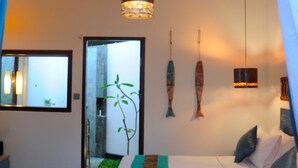 Un dormitorio con dos camas, ventilador de techo y decoración de peces en la pared.